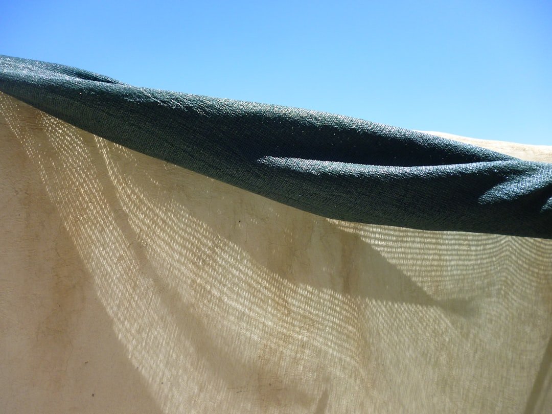 A large, plush microfiber drying towel being pulled across a wet car hood, leaving a streak-free, dry surface.