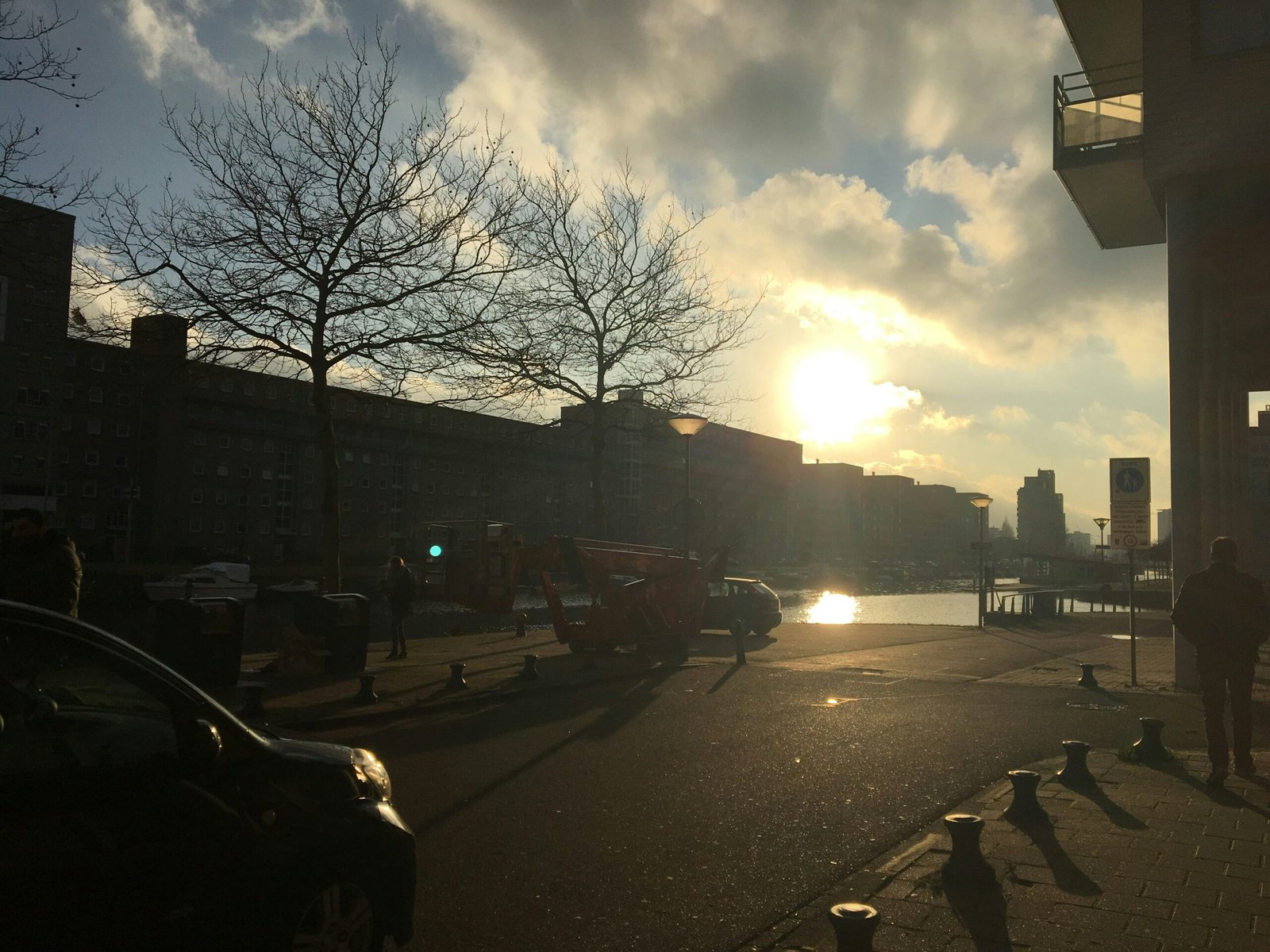 Une flotte de plusieurs fourgonnettes de livraison blanches, propres et identiques, garées en ligne bien ordonnée devant un entrepôt moderne.