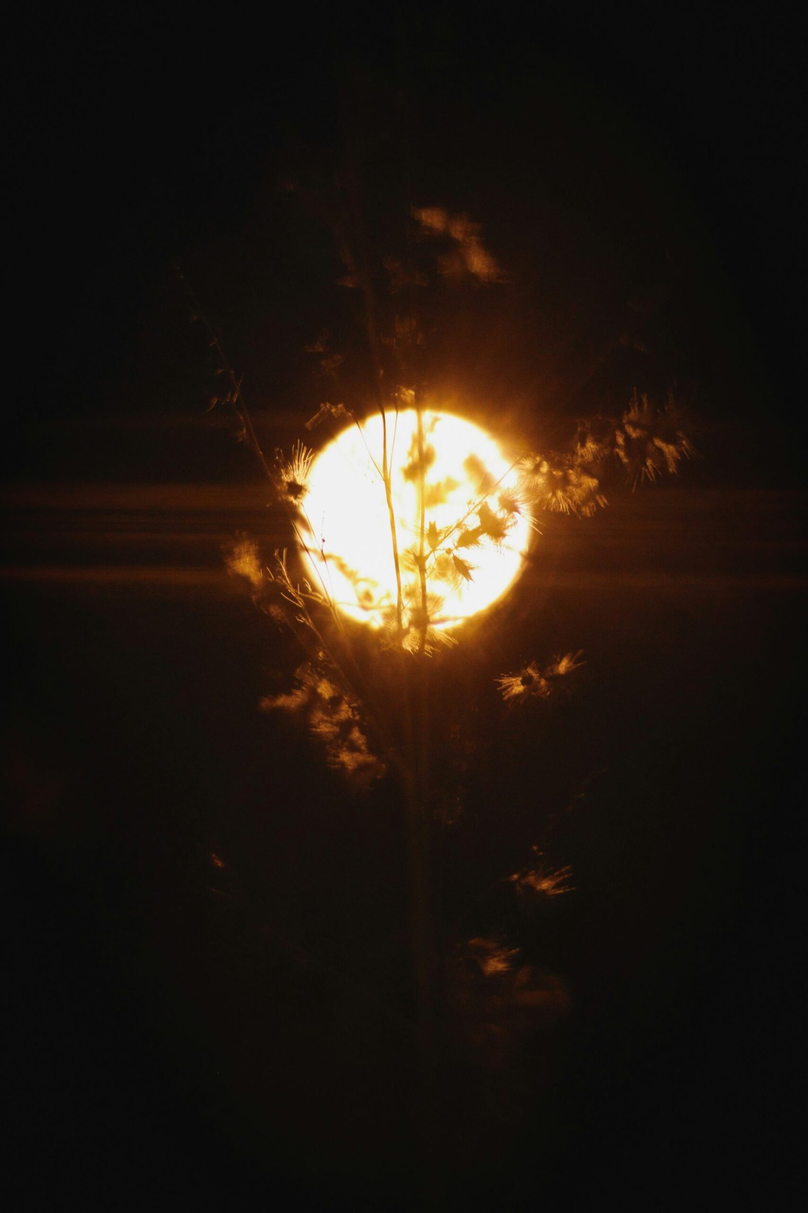 Un fourgon de livraison blanc conduit sur une autoroute au crépuscule, avec les phares allumés.