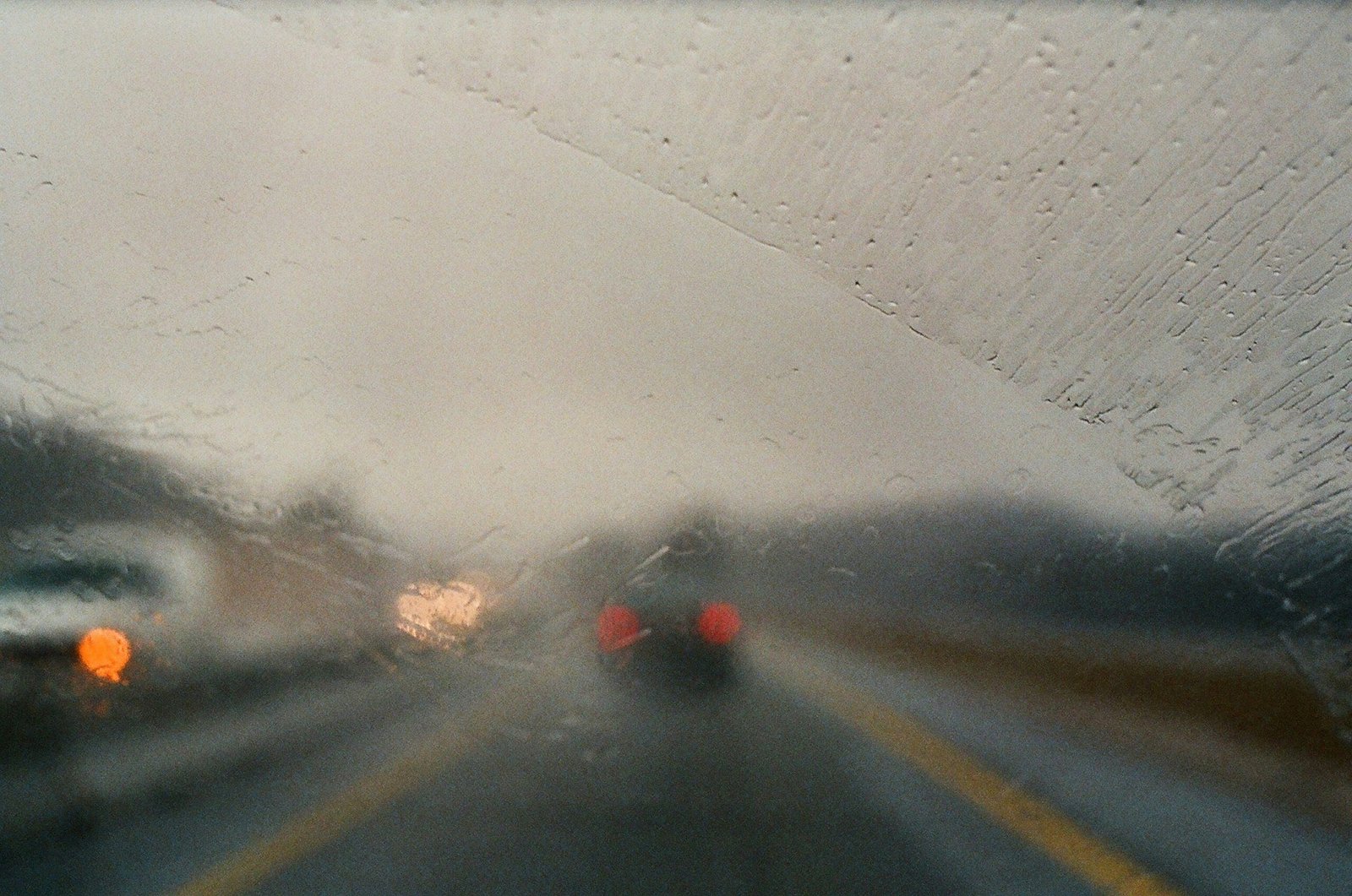 Highway driving during a rainstorm seen from inside a car with clear windshield wipers action