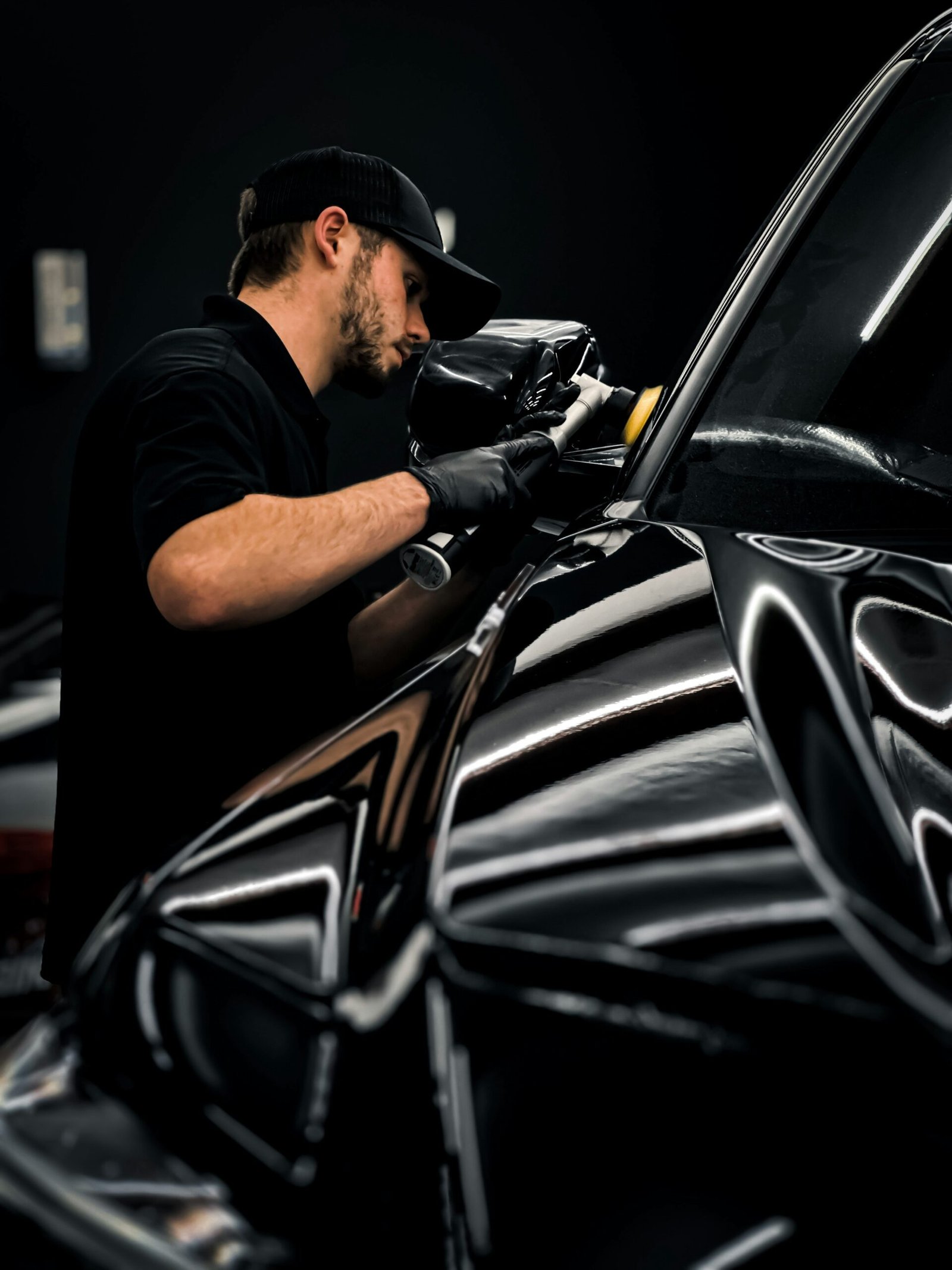 Close up of a shiny black car hood after a ceramic coating treatment reflecting the environment