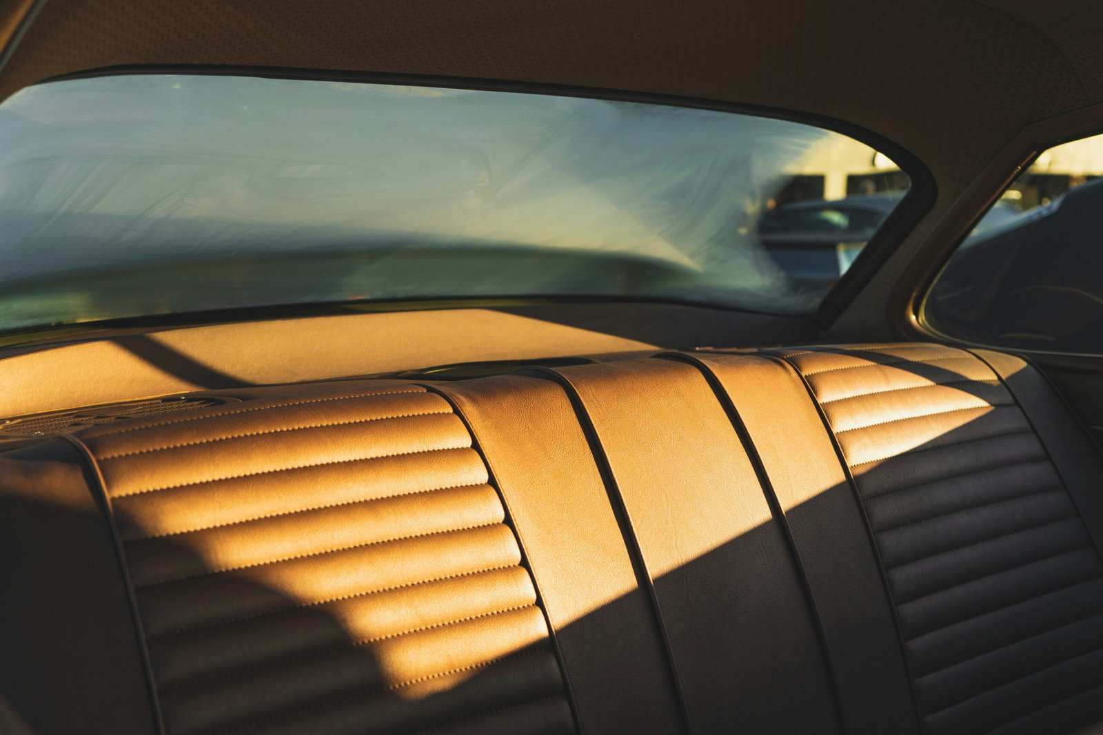 Close up of a luxury car with tinted windows parked nicely, reflection of the sun on the glass
