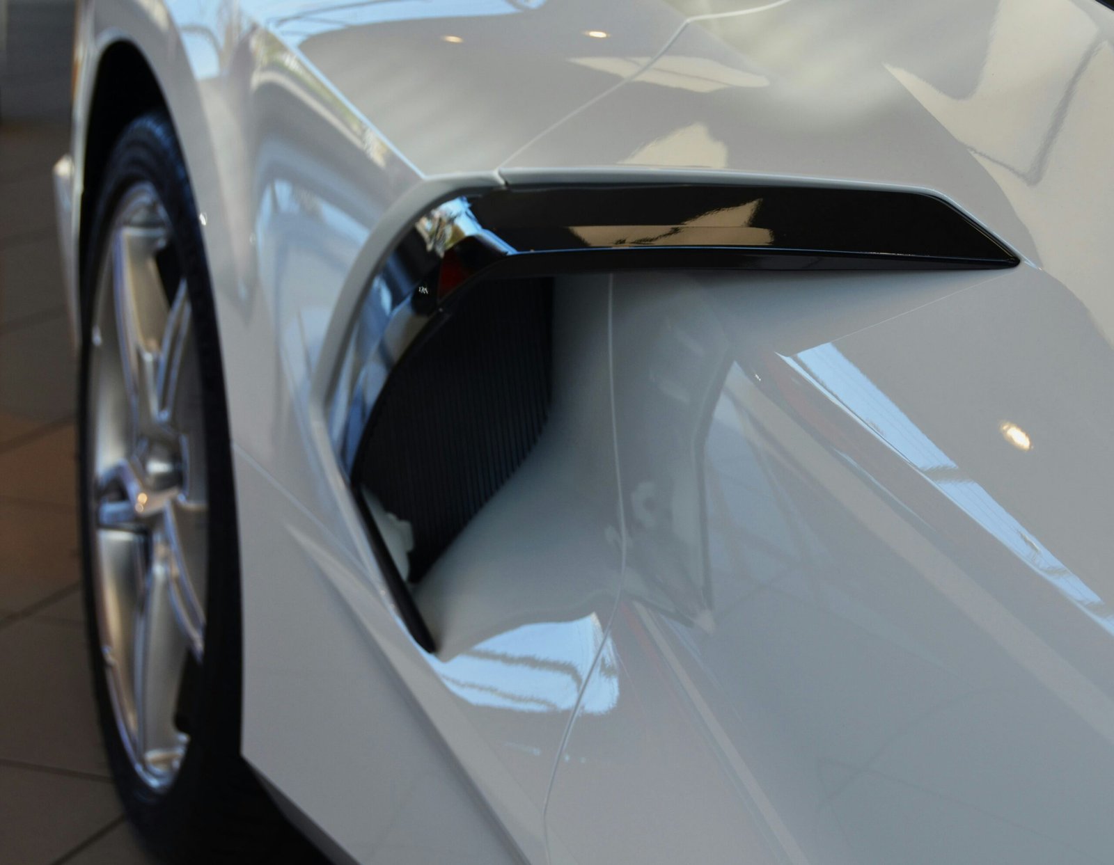 Professional car detailer using a dual-action polisher on a car hood, creating a mirror finish.