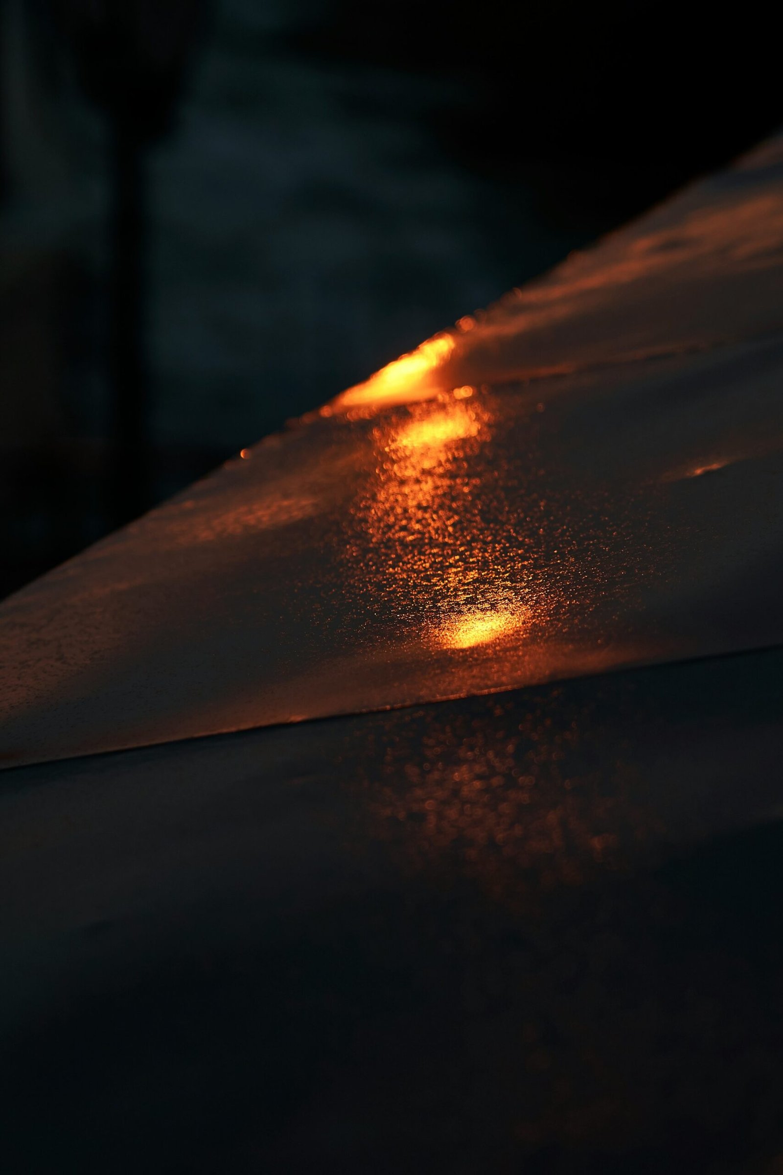 Close up of a ceramic coating being applied to a clean car fender, showing water beading off.
