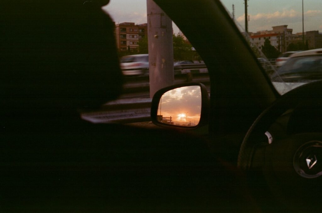 Rétroviseur latéral d'une voiture montrant une auto blanche. Une aide pour choisir quelle film teinté pour voiture.