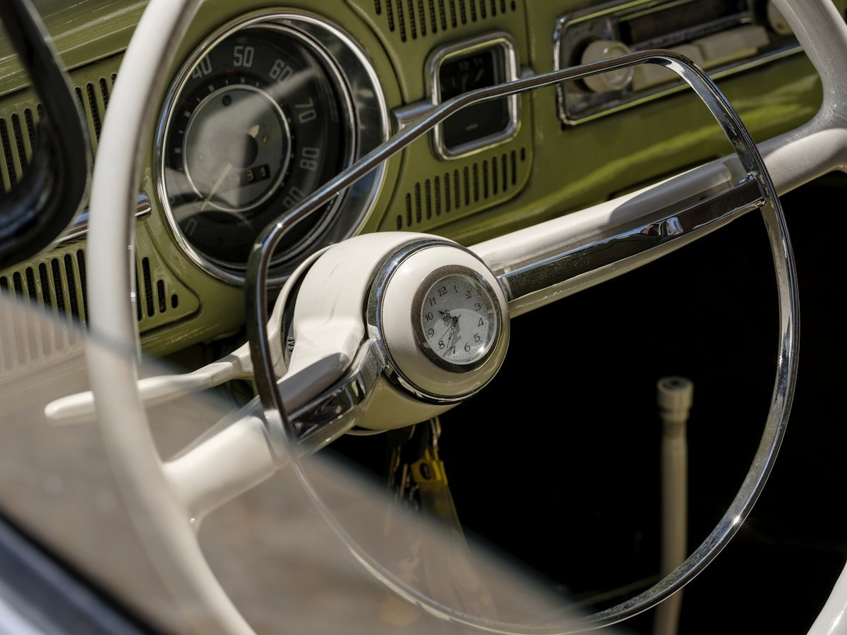 Close-up of a vintage car's steering wheel and dashboard.