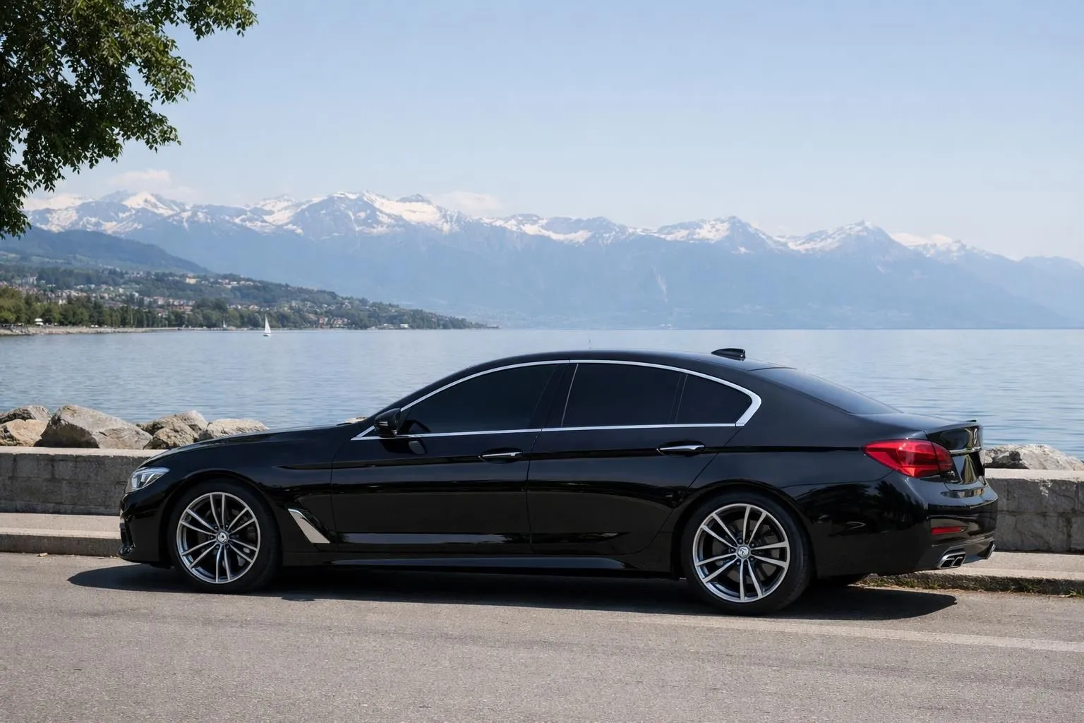Modern sleek vehicle with professionally tinted windows parked along Lake Geneva waterfront in Lausanne, Swiss Alps visible in background, demonstrating UV protection and heat reduction benefits for automotive window tinting services