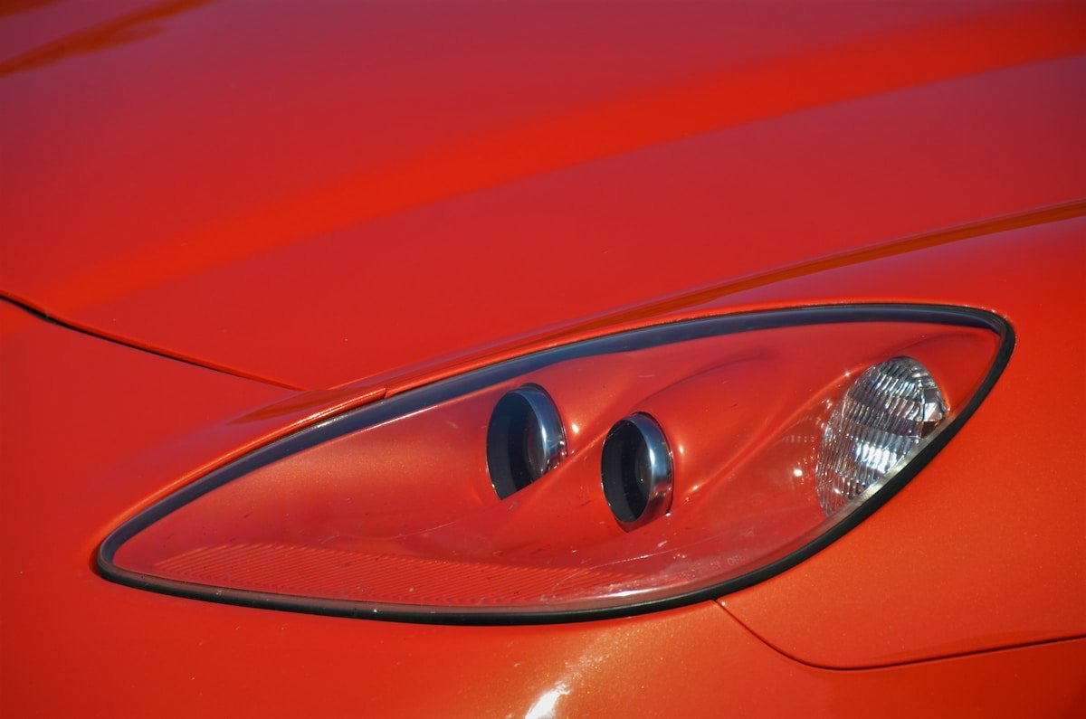 a close up of a red sports car's headlight