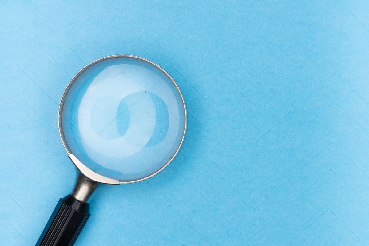 Loupe en métal sur fond bleu avec un motif en spirale.