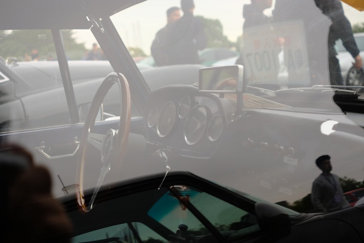 Intérieur d'une voiture vintage avec tableau de bord et rétroviseurs.