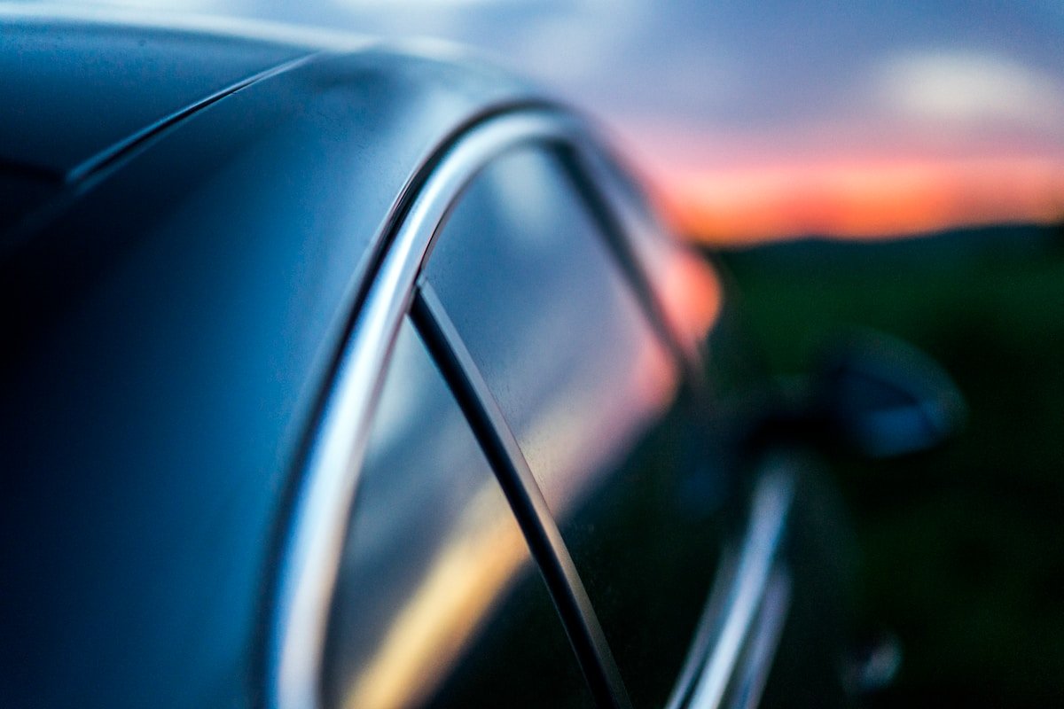 Reflet coloré du coucher de soleil sur la carrosserie d'une voiture.