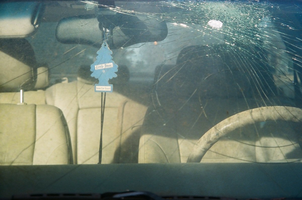 Voiture endommagée avec un arbre décoratif suspendu dans le pare-brise.