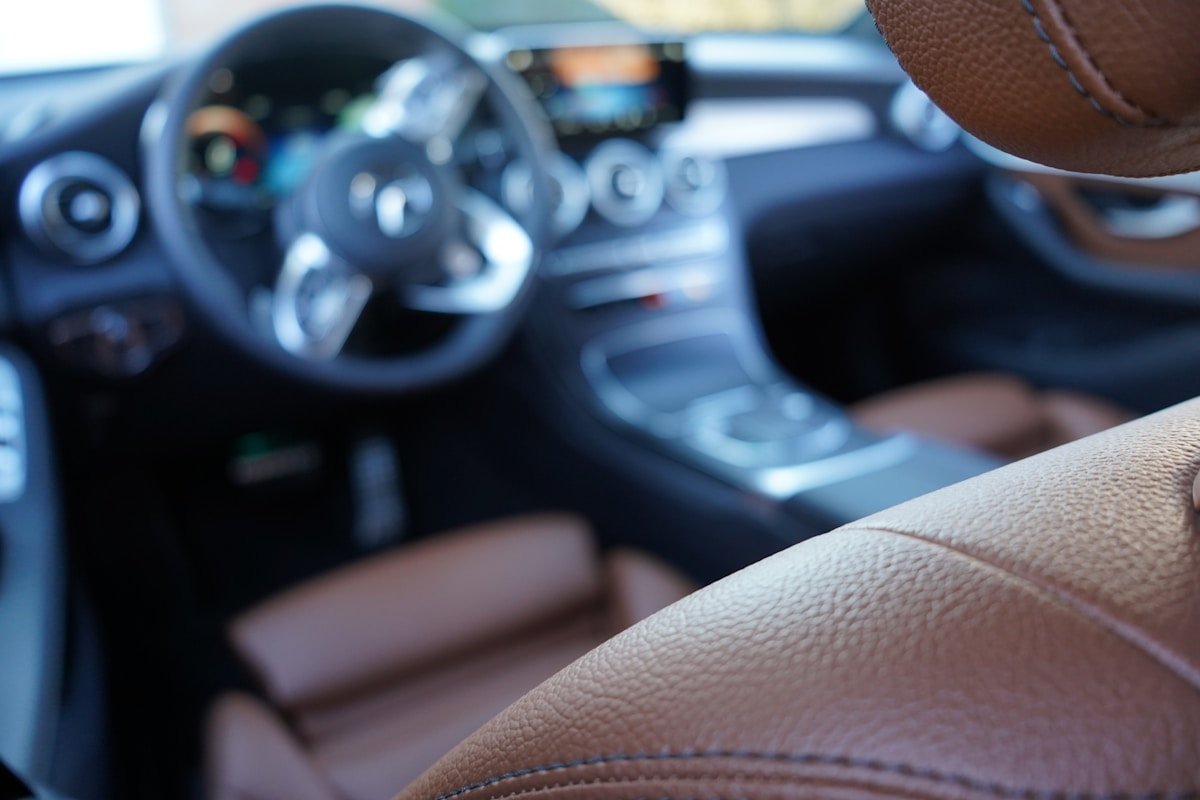 Intérieur de voiture avec volant, tableau de bord et siège en cuir.