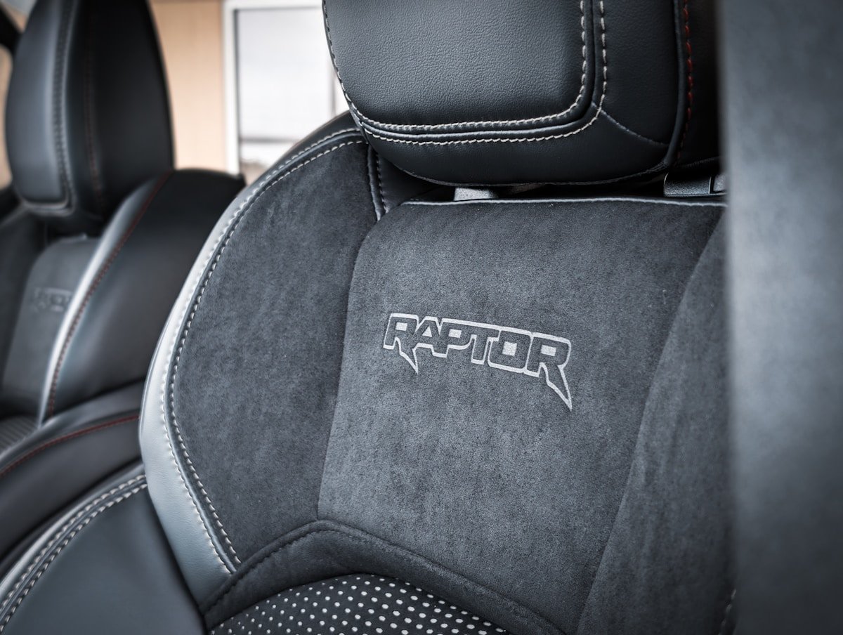 Close-up of a car seat with "raptor" logo.