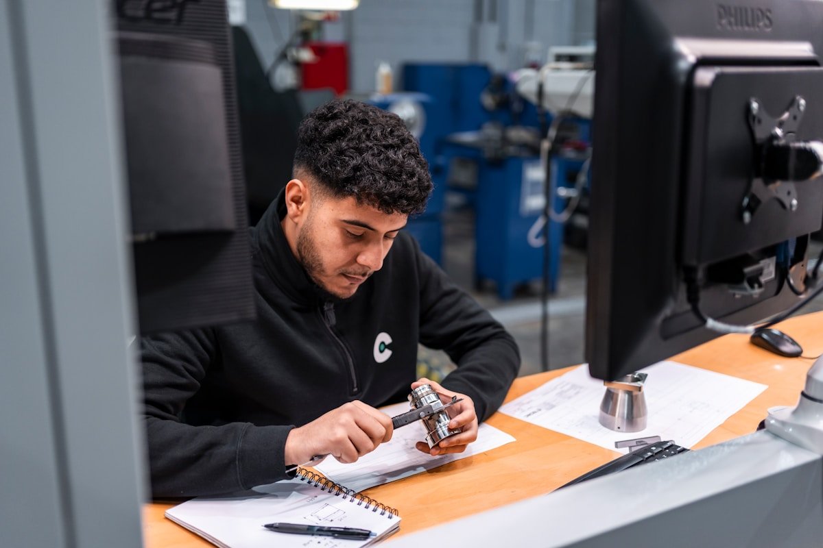 Homme travaillant avec des outils et des documents dans un atelier.