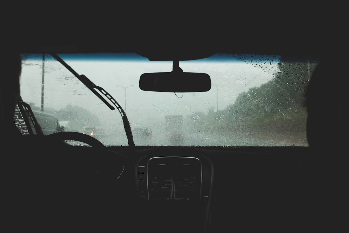 Intérieur de voiture par temps de pluie, vue du pare-brise.