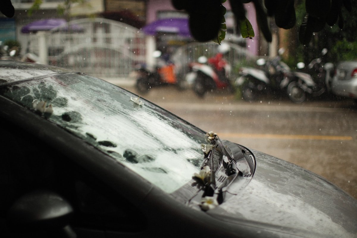 Pare-brise de voiture endommagé par la pluie et les intempéries.