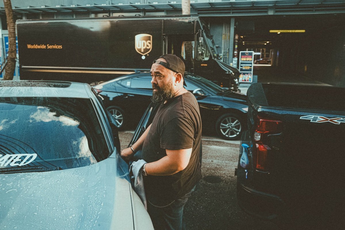 Homme barbu en uniforme de travail près d'un camion de livraison UPS.