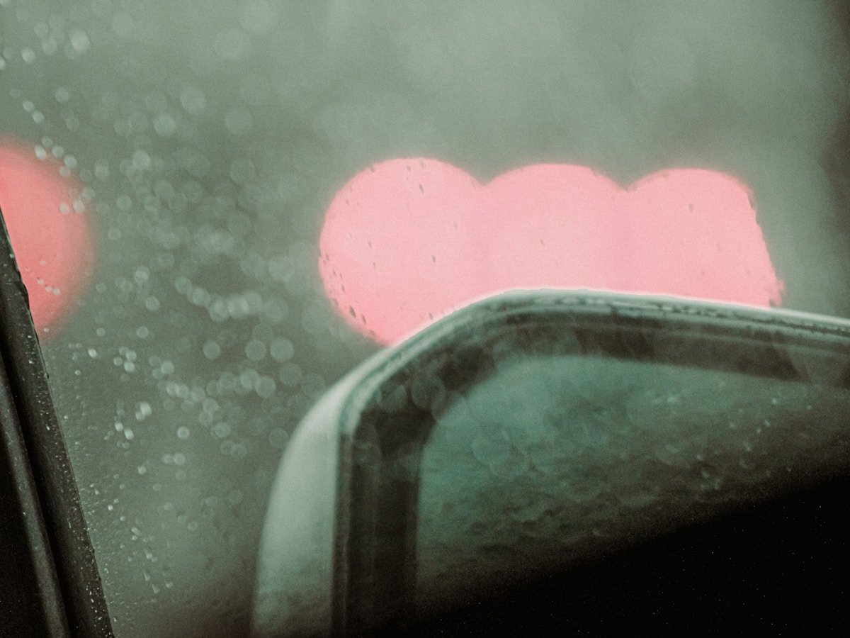 Gouttes de pluie sur une fenêtre avec un coeur rose.