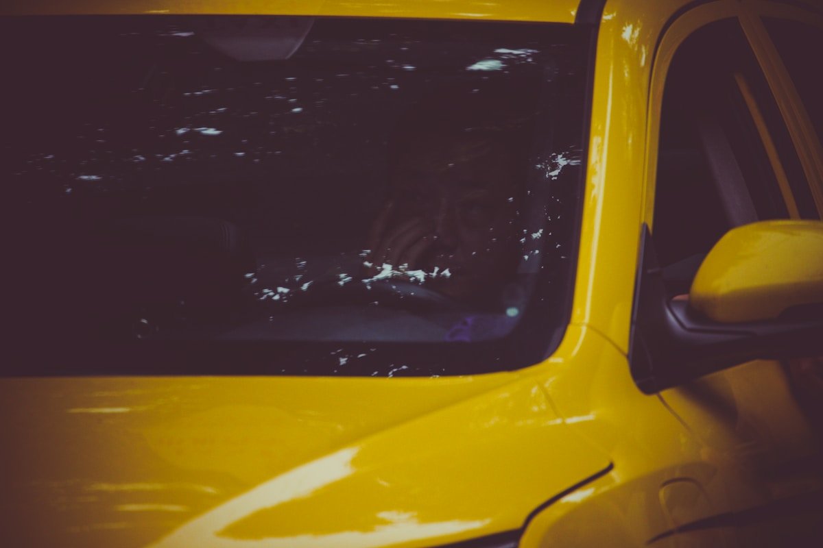 Voiture jaune endommagée avec fenêtre cassée.