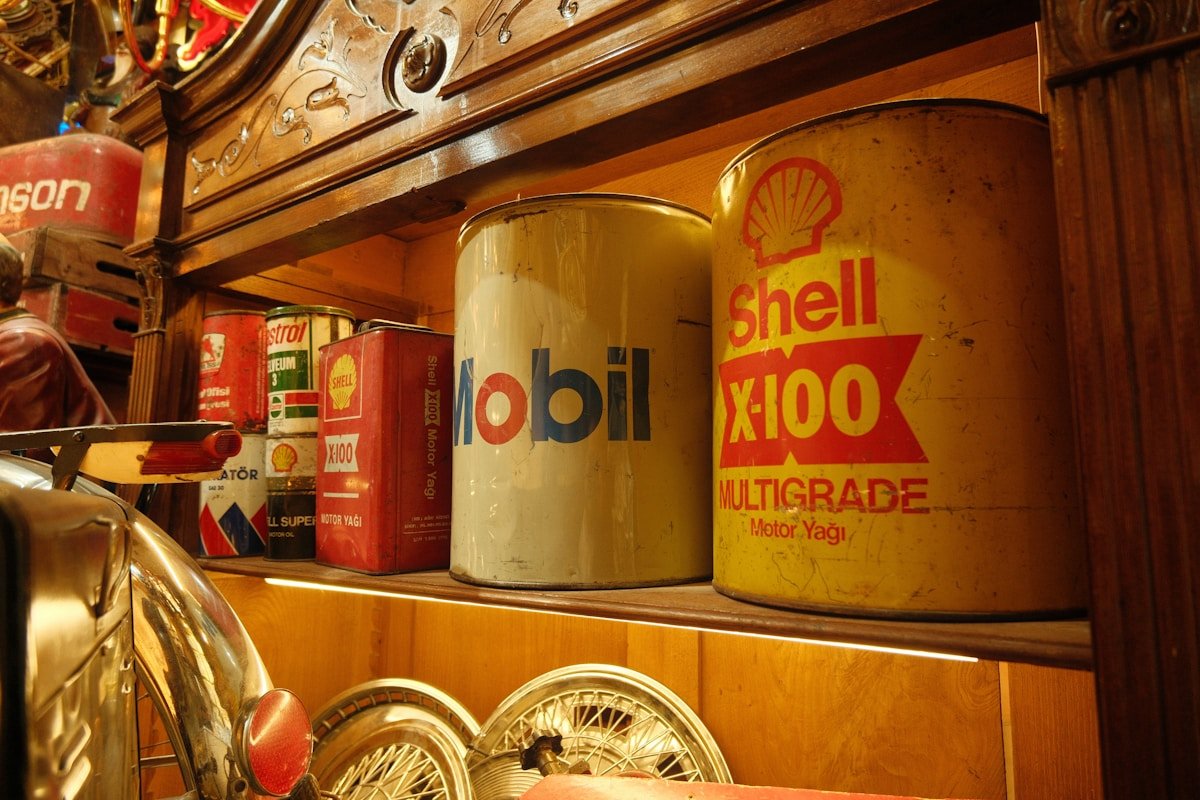 Étagère remplie de bidons d'huile Mobil et Shell dans un garage vintage.