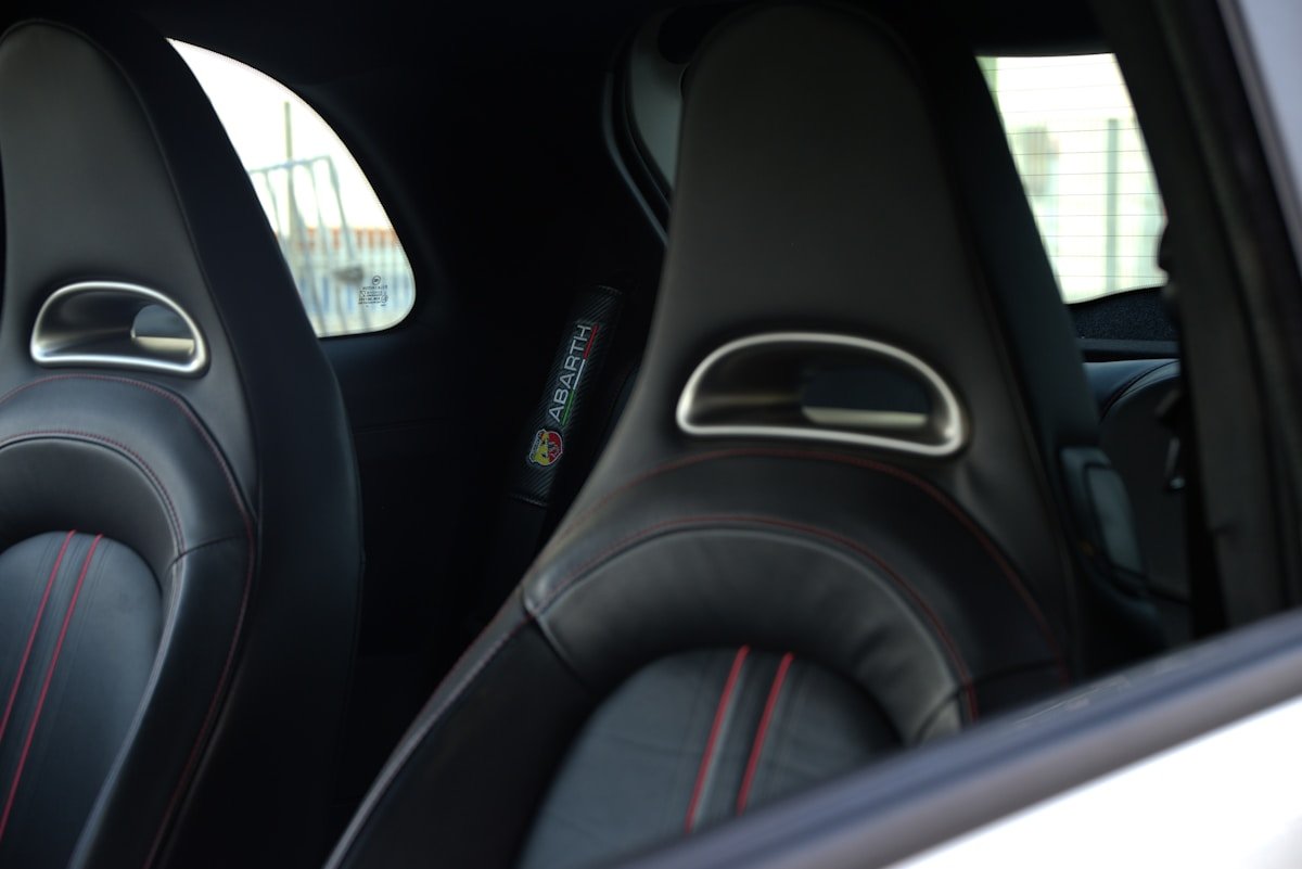 Sièges de voiture sport en cuir noir avec détails rouges.